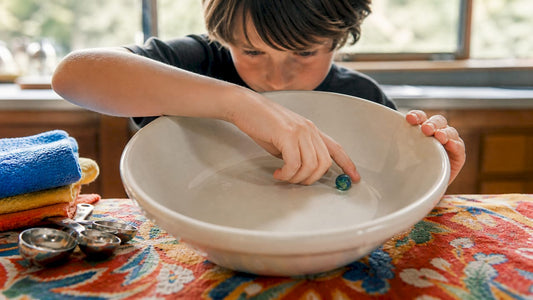 Child pushing marble inside bowl