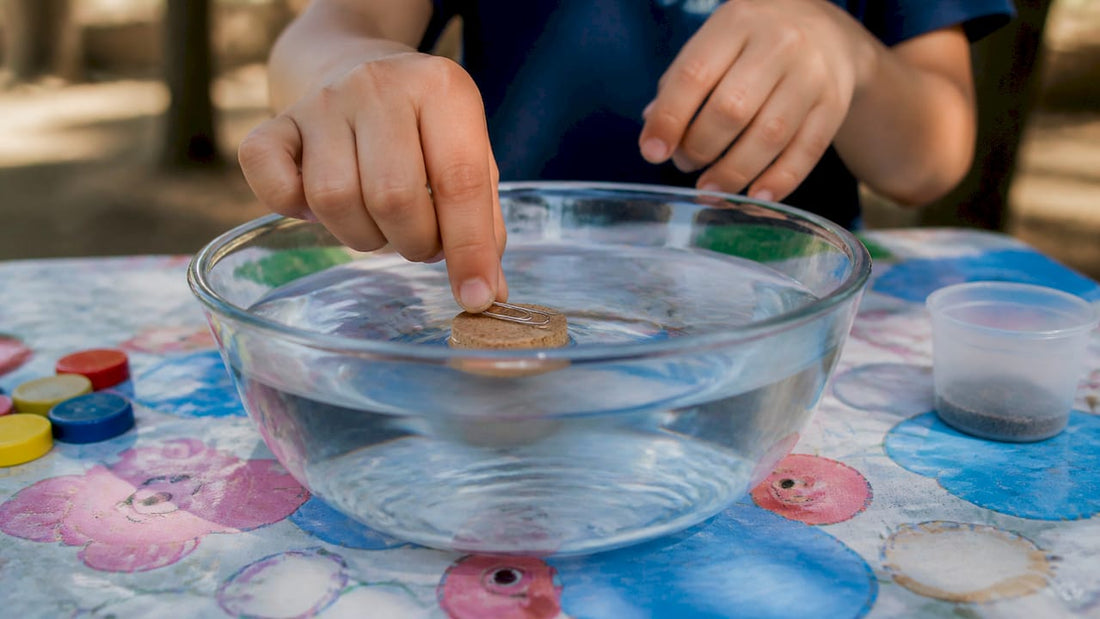 Child hands placing magnetized needle on cork in water