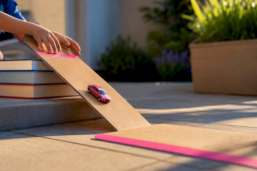 Child releasing toy car down a ramp