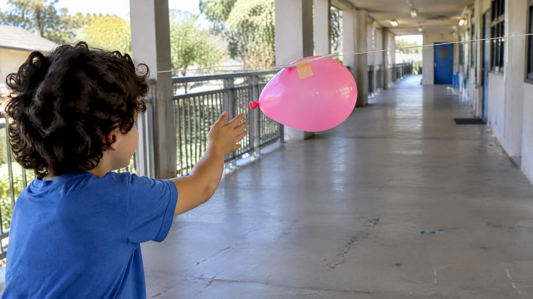 Child launching a balloon rocket experiment