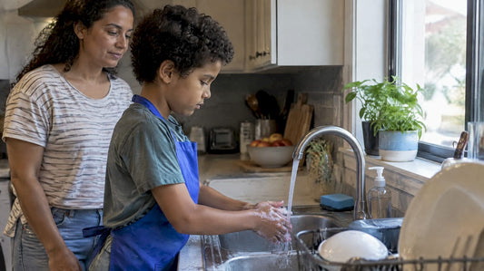 Child washing hands at a kitchen sink