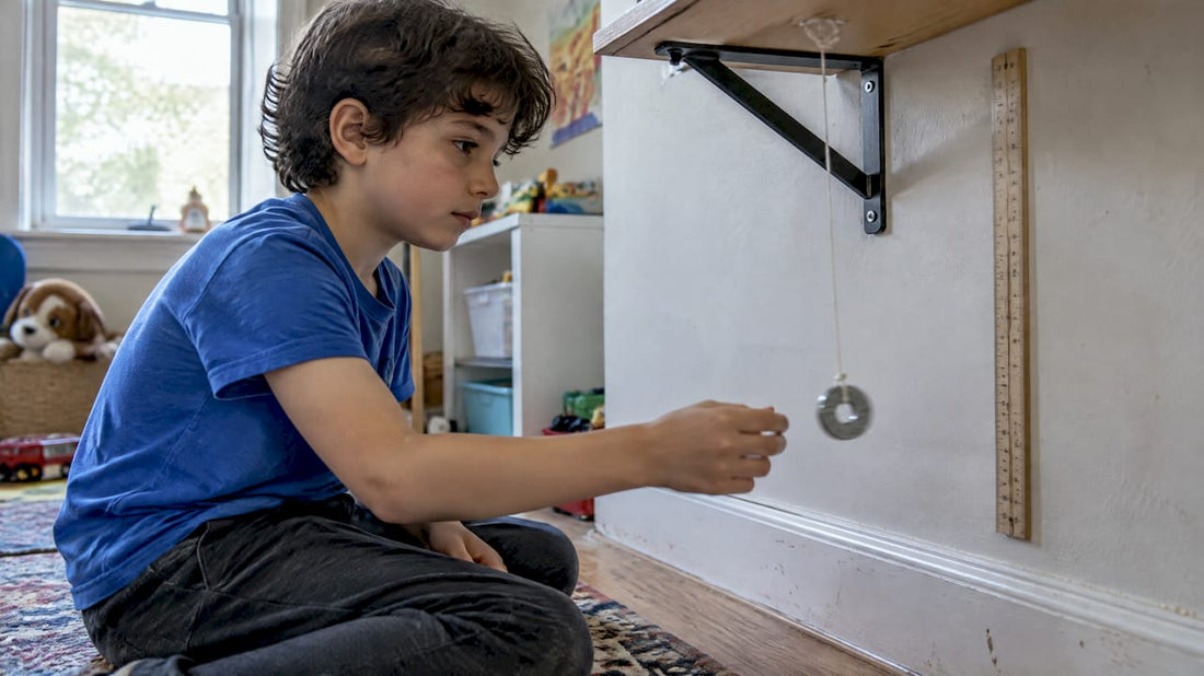 Child watching a swinging washer pendulum