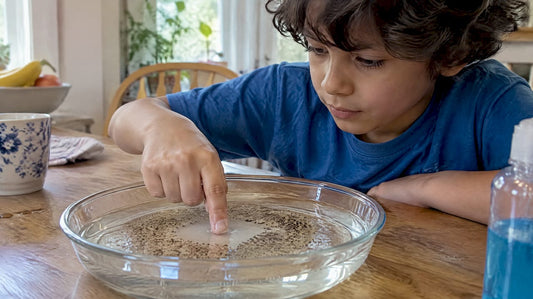 Child testing pepper and soap in water